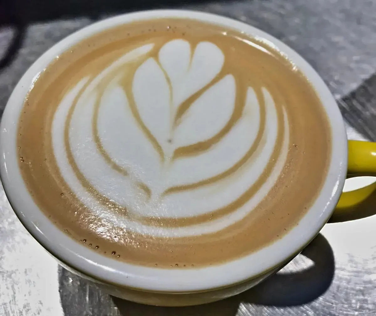 Café con latte art servido en taza de Donde María