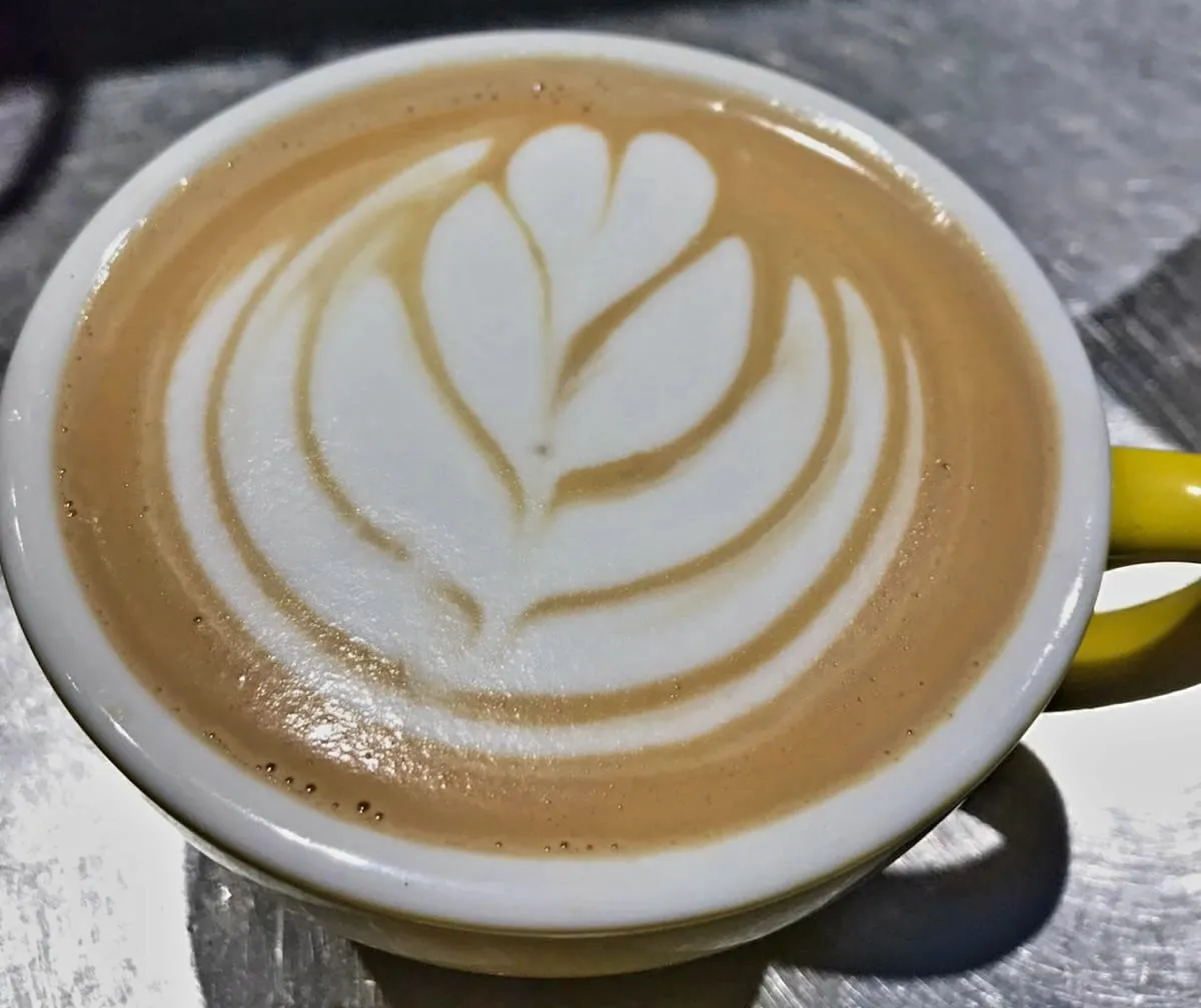 Café con latte art servido en taza de Donde María