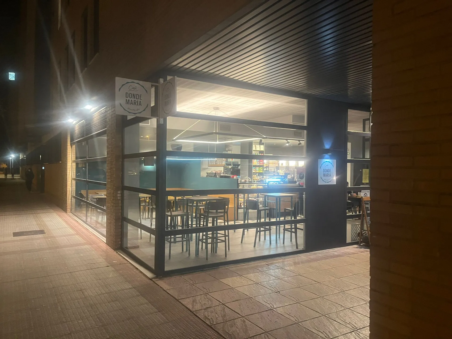 Fachada iluminada de Café Donde María de noche en Ansoáin